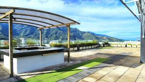 Una pérgola en un patio con montañas al fondo. en Apartaestudio cerca centros comerciales -Refugio romantico, en Ibagué