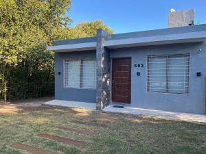 een klein huis met een bruine deur in een tuin bij Casa de descanso in Casa Grande