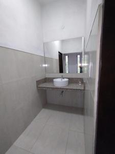 Un baño blanco con lavabo y espejo. en Casa de descanso, en Casa Grande
