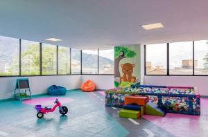 Una habitación infantil con un scooter en el medio. en Apartaestudio cerca centros comerciales -Refugio romantico, en Ibagué