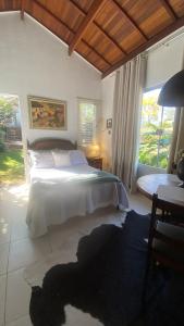 Un dormitorio con una cama y una ventana grande en Cabana graciosa e aconchegante, en Jaguariúna