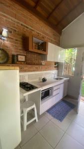 una cocina con fregadero y estufa horno superior en Cabana graciosa e aconchegante, en Jaguariúna