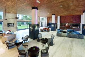 a living room with chairs and tables and a kitchen at Pullman Bali Legian Beach in Legian