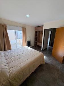 a bedroom with a large bed and a large window at Duplex confortable en Caleta Olivia in Caleta Olivia