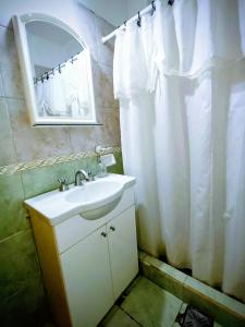 Un baño con lavabo y cortina de ducha blanca. en Despertar, en Santa Rosa