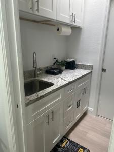 a kitchen with white cabinets and a sink at Geo Property- Beautiful and Private Apartment in Tampa
