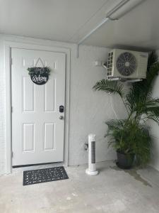 a white door with a fan and a plant next to it at Geo Property- Beautiful and Private Apartment in Tampa