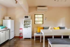 a living room with a white refrigerator and a table at Origami Chalet - Riverside in Hakuba