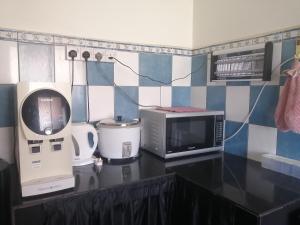a kitchen with a counter top with a microwave and appliances at Homestay Murah Lahad Datu in Lahad Datu +35 photos
