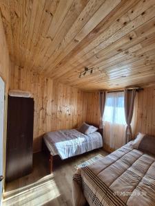 a bedroom with two beds in a wooden cabin at Casa Mirada Azul in Isla Negra