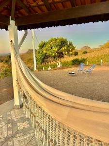 a hammock on a porch with two chairs at Casa de campo a 1 km do Thermas Hot World in Águas de Lindóia