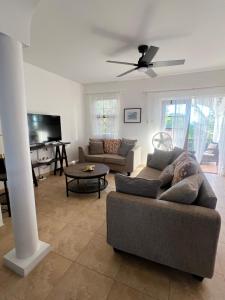 a person laying on a couch in a living room at Oistins Gem 2BR, 2BA Condo, Pool & Rooftop Patio, Walk to Miami Beach in Christ Church