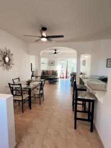 a dining room and living room with a table and chairs at Oistins Gem 2BR, 2BA Condo, Pool & Rooftop Patio, Walk to Miami Beach in Christ Church