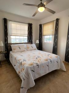 a bedroom with a large bed with a ceiling fan at Oistins Gem 2BR, 2BA Condo, Pool & Rooftop Patio, Walk to Miami Beach in Christ Church +21 photos