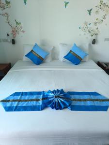 - un lit blanc avec une archet bleue dans l'établissement Mumzai House 2, à Ko Muk
