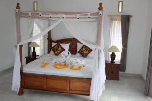 a bedroom with a canopy bed with two animals on it at Sekumpul Guest House in Sudaji +5 photos