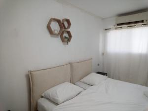 - une chambre dotée d'un lit avec une croix sur le mur dans l'établissement שלמות מול הכנרת, à Tibériade 1 autre photo