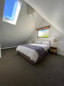 Un dormitorio con una cama grande en un ático. en The Black House with Stunning Outdoor Bath, en Lake Tekapo