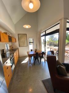 Una cocina y un comedor con mesa y sillas. en The Black House with Stunning Outdoor Bath, en Lake Tekapo