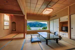 a living room with a table and a large window at Ryuguden in Hakone