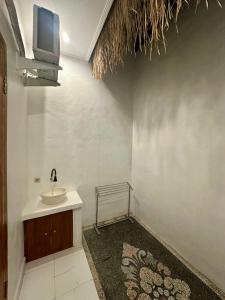 a bathroom with a sink and a tv on the wall at Casa Feliz Guest House in Bangli