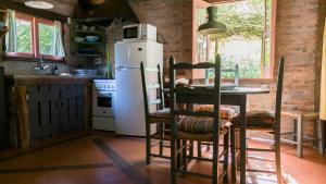 a kitchen with a refrigerator and a table and chairs at Posada Hale Koa in La Paloma