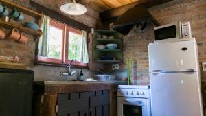a kitchen with a white refrigerator and a stove at Posada Hale Koa in La Paloma