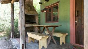 a table and bench on a porch of a house at Posada Hale Koa in La Paloma +11 photos
