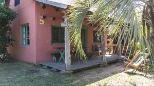 a house with a wooden porch in front of it at Posada Hale Nalu in La Paloma