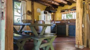a kitchen with a green picnic table in a room at Posada Hale Nalu in La Paloma