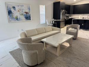 a living room with a couch and chairs and a table at Palm Luxe Residence in West Palm Beach