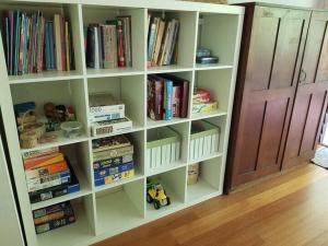a book shelf filled with books next to a door at Dragonflies on Billa in Point Lookout