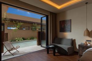 sala de estar con sofá, silla y piscina en ShanJuanYun Panoramic Sunlit Yulong Snow Mountain Hotel, en Baisha