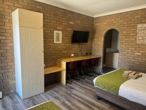 a bedroom with a bed and a desk with a television at Albury Classic Motor Inn in Albury +30 photos