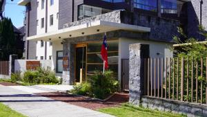 ein Gebäude mit einer Flagge davor in der Unterkunft Apartamento Pucón in Pucón