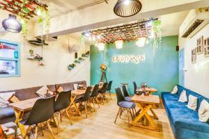 a restaurant with a blue couch and tables and chairs at Super Collection O Hotel Blueline in Juhi Bari
