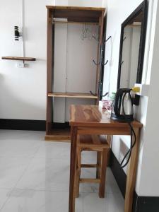 a room with a wooden desk with a telephone on it at DODAND Studio & Sunset Riverside Guesthouse in Don Det
