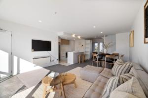 a living room with a couch and a table at Chic City Apartment, Sleeps 7, Pool, Gym & 2 Parks in Christchurch