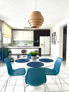 a kitchen with a table and blue chairs in a room at The Choliseo Bayside Stay in San Juan