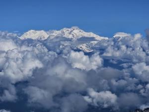 an aerial view of a snow covered mountain with clouds at Ghising Newas Homestay in Jālāpahār