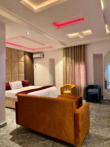 a hotel room with a bed and a couch at Luxarna Hotel and Spa in Port Harcourt