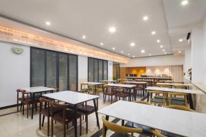 a restaurant with tables and chairs in a room at Thank You Hotel Sanya Bay Coconut Dream Corridor Branch in Sanya