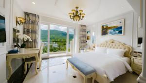 a bedroom with a bed and a desk and a window at Lan Rung Beach Resort in Long Hai