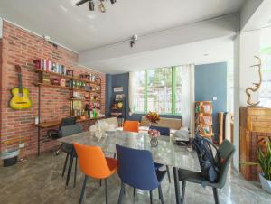 a dining room with a brick wall and a table and chairs at Friend & Sunshine Villa in Shenzhen