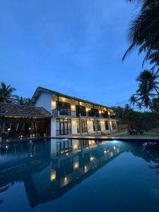 a villa with a swimming pool at night at Villa Nilnara in Ahungalla