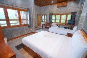 a bedroom with two white beds and a television at บ้านด้วงขวัญดอยรีสอร์ท  +56 photos