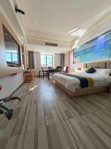 a bedroom with a large bed and a dining room at Wang Tian Shu Value Resort Hotel in Mengla