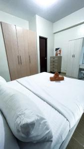 a large white bed with a brown hat on it at 13 Twin Balcony Escape in Iloilo City +4 photos