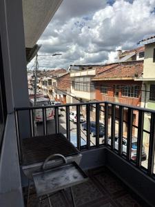 a balcony with a chair and a view of a parking lot at Encanto Colonial Apartamento Centro Histórico in Cuenca
