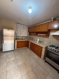 a kitchen with a white refrigerator and wooden cabinets at Encanto Colonial Apartamento Centro Histórico in Cuenca +5 photos